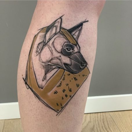 Tier-Tattoo eines Hundes in einem geometrischen Design auf dem Schenkel.